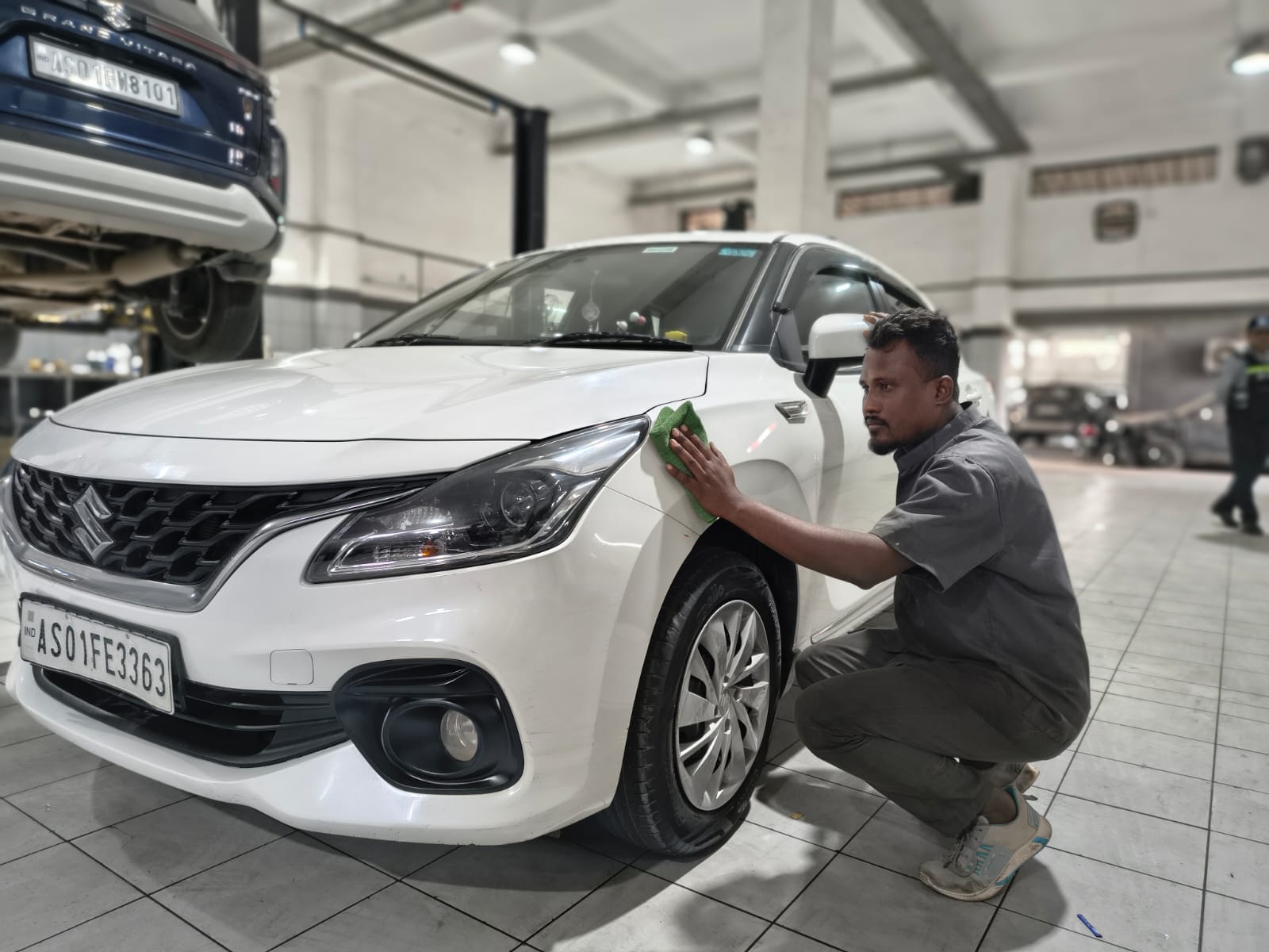 Maruti Suzuki service centre technician inspecting a vehicle